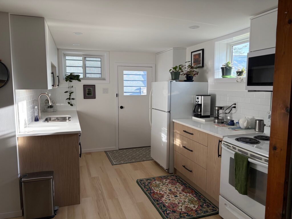 Small suite kitchen in Kamloops with woodgrain lower cabinets, white uppers and a galley layout