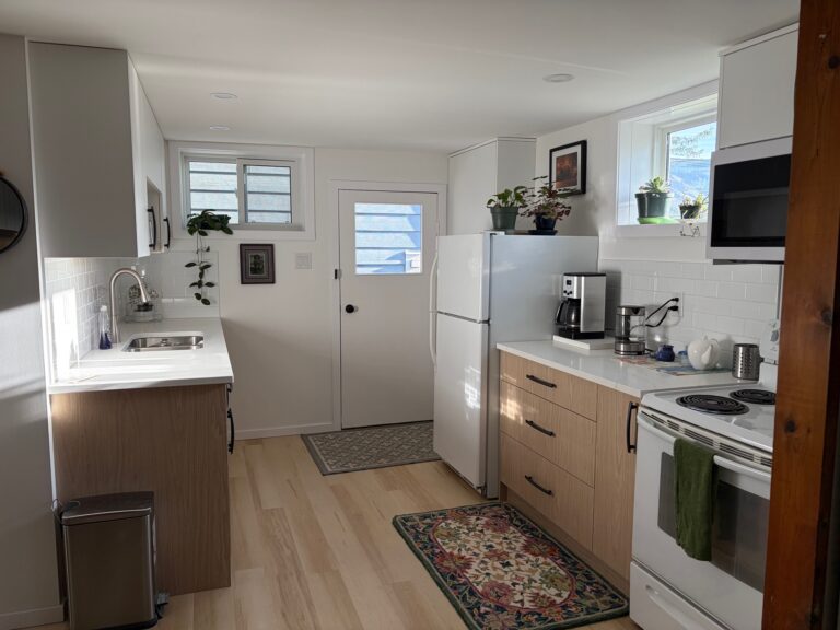 Small suite kitchen in Kamloops with woodgrain lower cabinets, white uppers and a galley layout