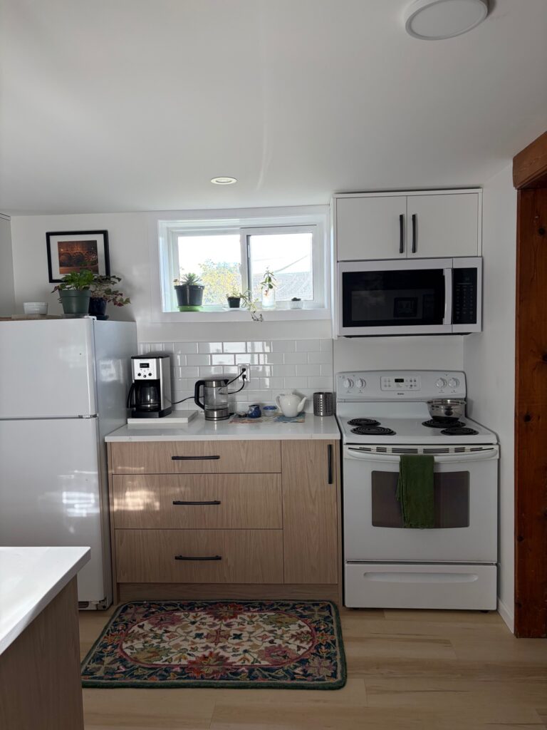 Woodgrain melamine drawers with black handles between the refrigerator and range